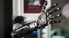 A paralyzed woman has been able to feed herself chocolate and move everyday items using a robotic arm directly controlled by thought, showing a level of agility and control approaching that of a human limb